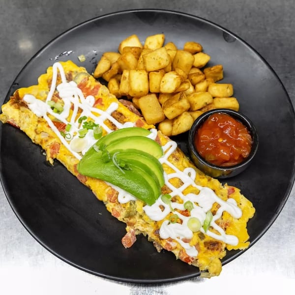 Omelet topped with avocado, sour cream, and green onions, served with home fries and salsa.