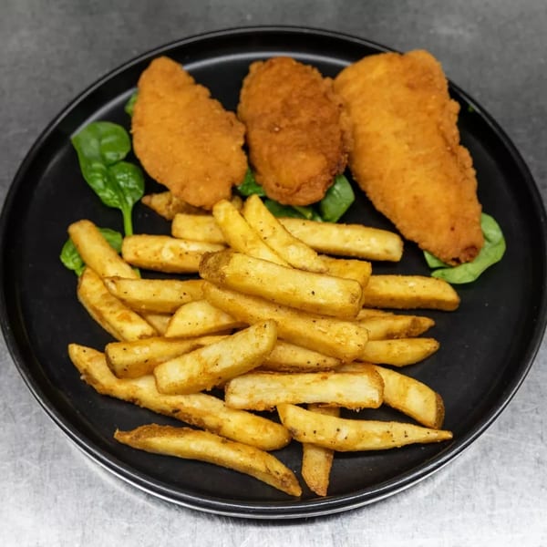 Crispy chicken tenders and golden french fries served on a black plate with a bed of spinach.